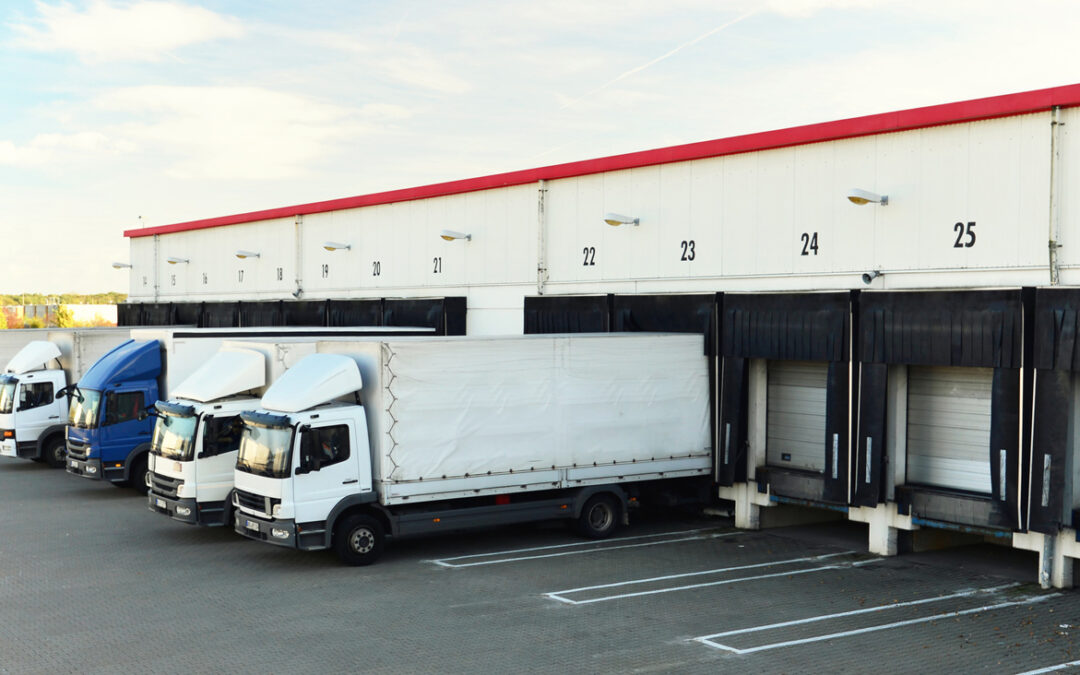 trucks are loaded with goods at the depot in a shipping company